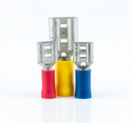 A red, a yellow and a blue insulated spade connector, without sleeve, standing upright on a white background.